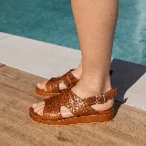 Sandalias de cuero color blanco con textura tipo reptil, plataforma marrón y hebilla metálica plateada.