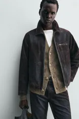 Cazadora de hombre de corte relajado, confeccionada en tejido con algodón de acabado flocado efecto terciopelo lavado, color marrón oscuro con efecto desgastado. Presenta cuello solapa, cierre frontal de cremallera, bolsillo con cremallera en el pecho y bolsillos laterales en la costura de la cadera.