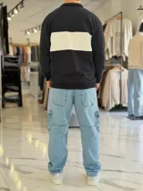 Hoodie de corte clásico con medio cierre y cuello alto, en color marrón con una franja horizontal blanca en el pecho que incluye el logo estampado en negro. Presenta además un pequeño bordado en el hombro izquierdo y puños y cintura elastizados de rib.