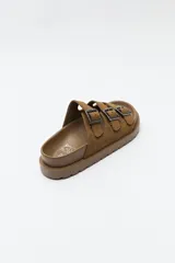 Sandalia negra tipo slide con plataforma gruesa y tres tiras ajustables con hebillas metálicas plateadas. La capellada es de material con textura de gamuza o nobuck.