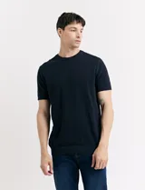 Remera de punto color beige, de manga corta y cuello redondo.