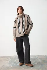 Sweater de punto grueso con cuello tortuga, diseño de rayas verticales con patrón geométrico en contraste, manga larga y corte holgado.