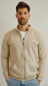 Campera de algodón color beige con cierre frontal completo, cuello alto tipo bomber, bolsillos tipo canguro y puños y ruedo acanalados.