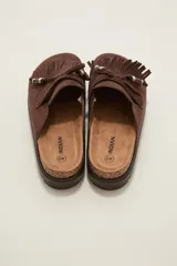 Suecos tipo mocasín color chocolate, confeccionados en material gamuzado. Presentan un diseño con flecos frontales, cordones decorativos con cuentas y una suela de plataforma plana de goma.