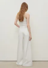 Pantalón de jean estilo wideleg, de tiro alto y corte largo, con diseño de cinco bolsillos, trabillas para cinturón y cierre frontal con cremallera y botón.