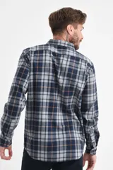 Camisa de manga larga con estampado de cuadros en tonos azul, gris y líneas finas en color naranja. Presenta cuello con botones, cierre frontal abotonado y un bolsillo en el pecho.