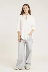 Camisa blanca de corte oversize con detalle de strass aplicado en toda la prenda, cuello camisero clásico y mangas largas con puños.