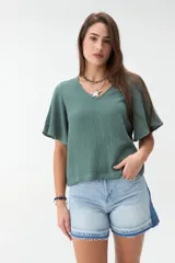 Blusa verde de manga corta con escote en V y mangas amplias acampanadas, confeccionada en tejido texturado.