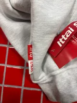 Hoodie gris jaspeado con capucha, bolsillo frontal tipo canguro y estampado gráfico en el pecho con la marca ittaistars.