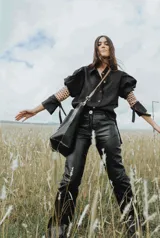 Pantalón de cuero color marrón con estampado abstracto, corte acampanado y abertura en el ruedo.