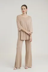 Pantalon de corte recto y holgado, confeccionado en tejido de punto con acabado brillante tipo lurex, con cintura elástica.