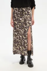Falda larga de corte recto con abertura lateral pronunciada, confeccionada en tejido fluido con estampado abstracto en tonos tierra y crema.