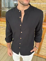 Camisa de cuello mao en color negro, confeccionada en tela liviana, con mangas largas y botones frontales en tono madera.