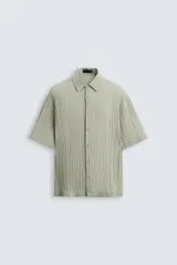 Camisa de manga corta con cuello solapa, confeccionada en tejido de mezcla de lyocell con textura de efecto arrugado y cierre frontal de botones.