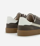 Championes de estilo deportivo tipo chutera, confeccionados en poliuretano con recortes en contraste. Presentan punta redondeada, cordones bicolores y suela plana color caramelo.