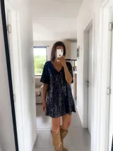 Túnica corta de color negro, completamente cubierta de lentejuelas brillantes. Presenta un escote en V, mangas cortas holgadas y un corte recto y cómodo.