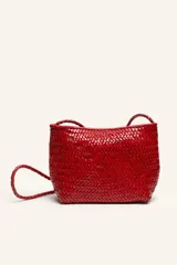 Cartera tipo bandolera confeccionada en 100% cuero vacuno trenzado a mano, color rojo, con estructura espaciosa y correa larga trenzada.