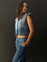 Chaleco de jean con cuello y pequeñas mangas, con alforzas texturizadas en los laterales.