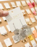Caravanas colgantes de diseño floral calado, compuestas por pétalos metálicos superpuestos con acabado plateado brillante.