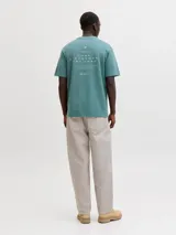Remera de manga corta color verde con cuello redondo y calce relajado. Presenta un pequeño bordado o estampa en el pecho.