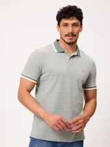 Remera polo de piqué de algodón melange color verde, con cuello y puños en tono contrastante con borde blanco, cierre frontal de dos botones y pequeño bordado en el pecho.