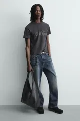 Bolso shopper negro de hombro, de diseño liso y estructura suave, con compartimento principal y asa integrada.