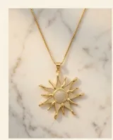 Cadena de acero con baño de oro y dije en forma de sol con incrustaciones de circonias.