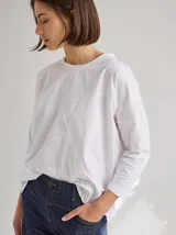 Remera de silueta relajada con cortes geométricos en el frente y costuras a la vista en tono contrastante. Presenta cuello redondo y mangas largas.