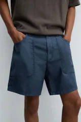 Bermuda de algodón color azul marino con efecto lavado, corte regular fit. Presenta bolsillos frontales de plastrón, bolsillo cerillero y bolsillo trasero de vivo. Cierre frontal con cremallera y botón.
