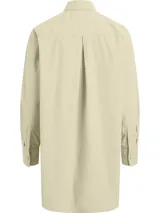 Camisa oversized color beige, confeccionada en algodón regenerativo, con cuello en punta, puños segados, bajo redondeado, plisado trasero central, bolsillo de parche en el pecho y cierre de botones.