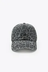 Gorra con visera confeccionada en sarga de algodón 100%, con estampado animal print en tonos grises y negros. Presenta costuras marcadas y ajuste en la parte posterior.