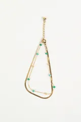 Tobillera dorada de doble cadena, una de eslabón plano y otra con cuentas de colores verde, celeste y rosa.