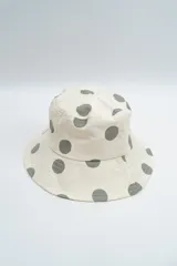 Gorro tipo bucket color crema con estampado de lunares en tono verde oliva.
