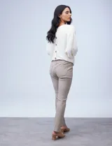 Pantalón de gabardina elastizada color beige, marca Sioni, de corte recto. Tiene pretina con pasadores, botón y cierre. Delantera con bolsillos simulados y trasera con bolsillos aplicados.