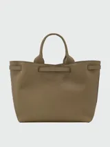 Bolso tote grande Longchamp modelo Le Smart Flow, color tostado, confeccionado en cuero con textura granulada. Cuenta con doble asa de mano, tira decorativa con broche metálico dorado en la parte frontal y diseño estructurado.