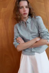 Camisa entallada de cuello solapa y manga larga, con estampado de cuadros vichy en tonos azul claro y blanco. Cierre frontal con botones.