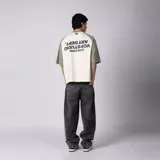 Remera de algodón con mangas raglán color verde militar y cuerpo color crudo, con cuello redondo y diseño estampado en el pecho con el texto 'ART DEPT. VCP'.