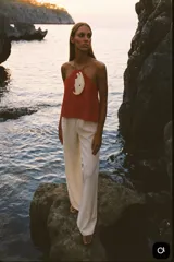 Top rojo tomate de cuero con pieza de nácar en el centro.