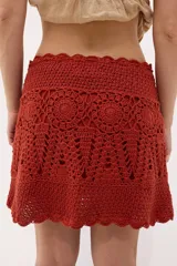 Minifalda celeste tejida al crochet con lurex plateado, cintura con cordón ajustable y diseño calado.