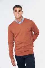 Suéter de tejido fino color azul marino, con cuello en V y manga larga. Presenta un pequeño logo bordado en el pecho.