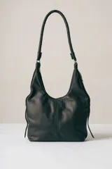 Cartera tipo hobo de cuero negro, con diseño de costura central vertical y manija trenzada fija.