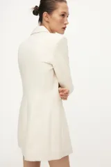 Blazer larga negra con cuello solapa, manga larga y bolsillos de vivo en el delantero. Cierre frontal con dos botones plateados.