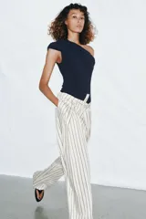 Body azul marino de escote asimétrico con un hombro descubierto, detalle de frunces en el busto y cierre de botones a presión en la parte inferior.