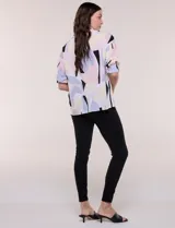 Blusa de gasa con estampado abstracto en tonos rosado, celeste, beige y negro, de silueta holgada, con cuello camisero, escote en V con media abotonadura y mangas largas de hombro caído.