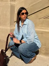 Camisa celeste a rayas verticales con calce relajado, mangas largas y cuello clásico.