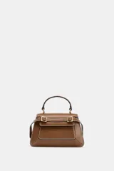 Bolso de mano tipo city color marrón, con diseño estructurado, costuras a la vista en color blanco y detalles de hebillas metálicas decorativas en la parte frontal. Cuenta con asa de mano superior, correa ajustable para usar como bandolera y cierre mediante solapa con imán.