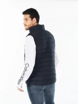 Chaleco acolchado azul marino con cierre de cremallera y cuello alto.