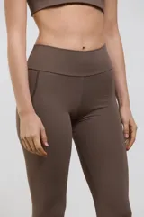 Calza deportiva larga de tiro alto, con bolsillos laterales integrados. Confeccionada en tejido elastizado de compresión media, con diseño liso y corte al tobillo.