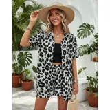 Conjunto de dos piezas compuesto por una camisa de manga corta con cuello italiano y cierre frontal de botones, y un short con cintura elástica y bolsillos laterales. Ambas prendas presentan un diseño estampado de animal print.