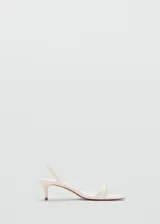 Sandalias de tacón fino bajo tipo kitten heel, color marfil, con tira delantera fina y tira ajustable en el talón.